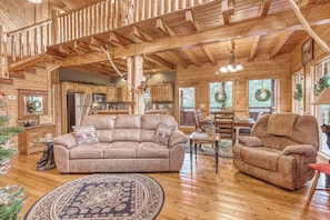 A cozy log cabin interior with a living room, kitchen, and dining area. - Luxury! 2 Master Suites w/Fireplaces|Game Room (SEVIERVILLE)