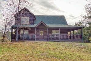 A log cabin with a porch and a green roof. - Luxury! 2 Master Suites w/Fireplaces|Game Room (SEVIERVILLE)