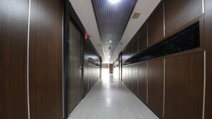 Un pasillo moderno y bien iluminado con paneles de madera y piso de color claro.