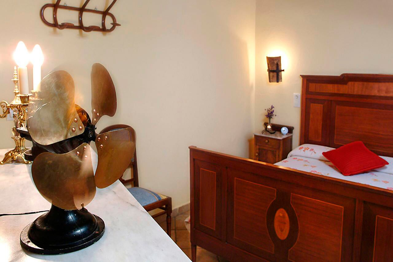 Une chambre à coucher avec un lit en bois, une table de chevet avec une lampe et une chaise.