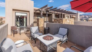 An outdoor patio with a fire pit, seating, and a pergola. - Steps to Pool - Modern 3BR Golfside w/ Fire Pit (St. George)