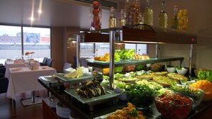 Um buffet com diversos alimentos e acompanhamentos.