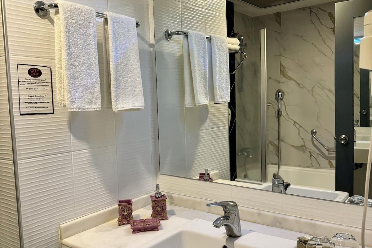 bathtub, hair dryer, slippers, towels