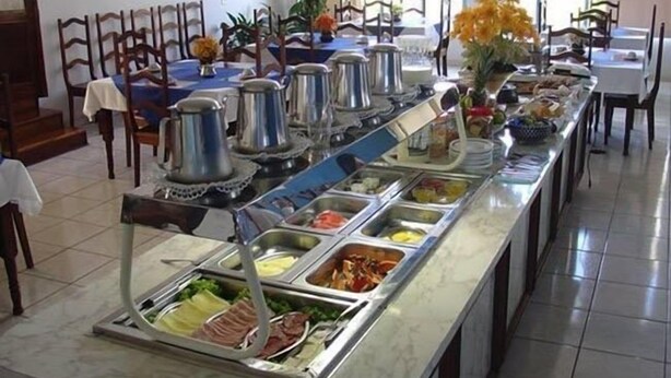 Montaje de bufé con distintas estaciones de comida, que incluyen carnes, ensaladas y frutas.