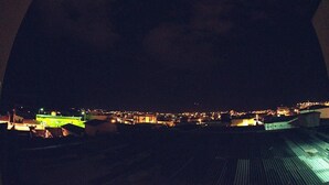 A nighttime view of a cityscape with buildings illuminated by artificial lights. - Minas Brasil Hotel (Salinas)