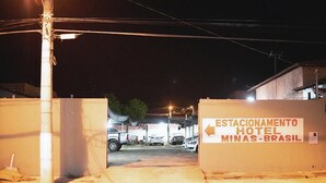 A hotel entrance with a sign reading "Estacionamento Hotel Minas-Brasil" and a parking area with cars. - Minas Brasil Hotel (Salinas)