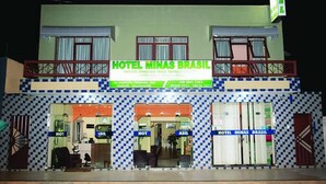 A two-story building with a sign reading "HOTEL MINAS BRASIL" and a balcony with railings. - Minas Brasil Hotel (Salinas)