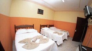 A hotel room with two beds, a television on a stand, and a small window. - Minas Brasil Hotel (Salinas)