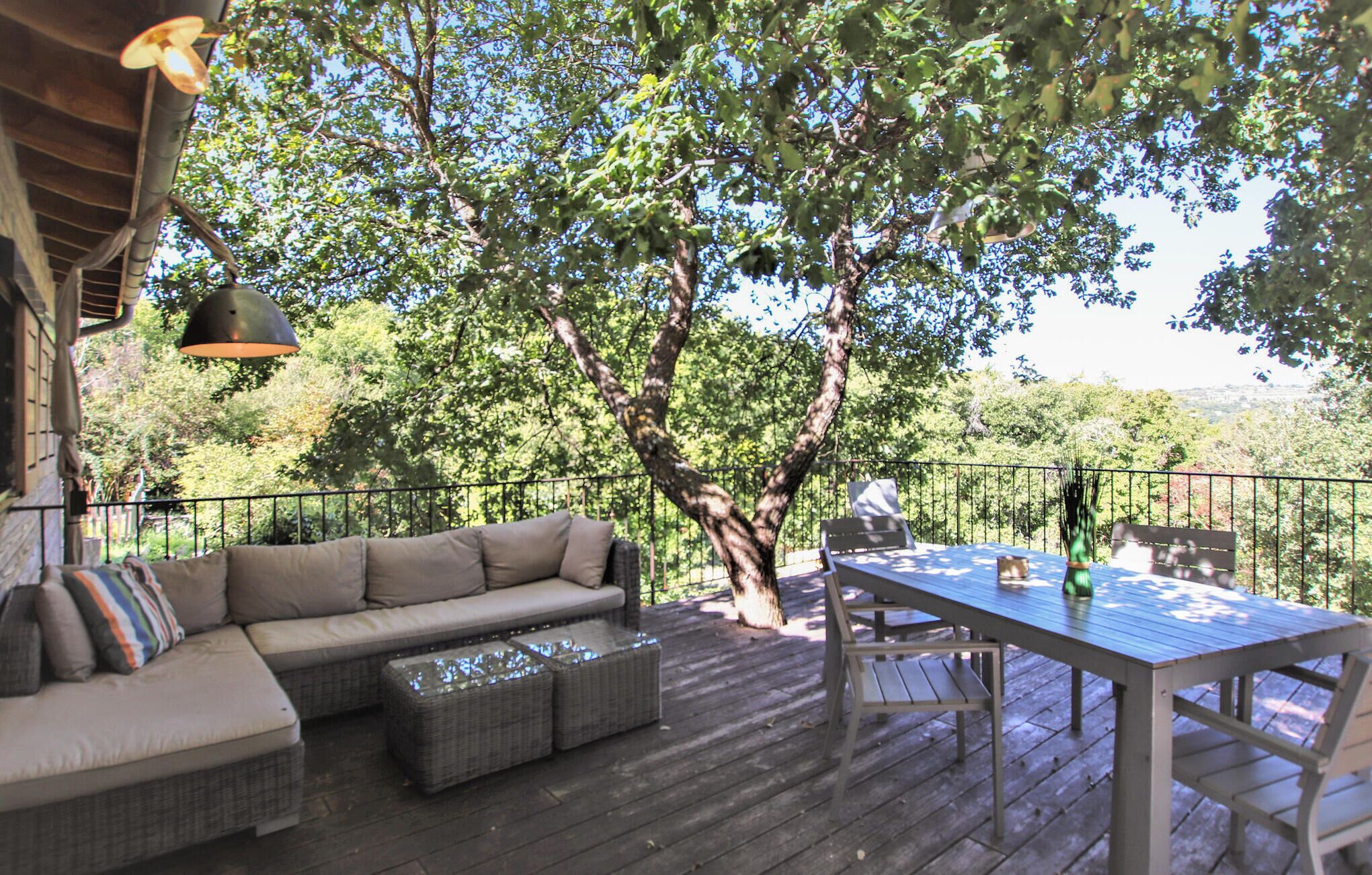 An outdoor deck with a sofa, table, and chairs.