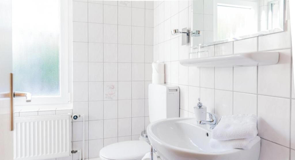 Ein Badezimmer mit Toilette, Waschbecken und Spiegel.