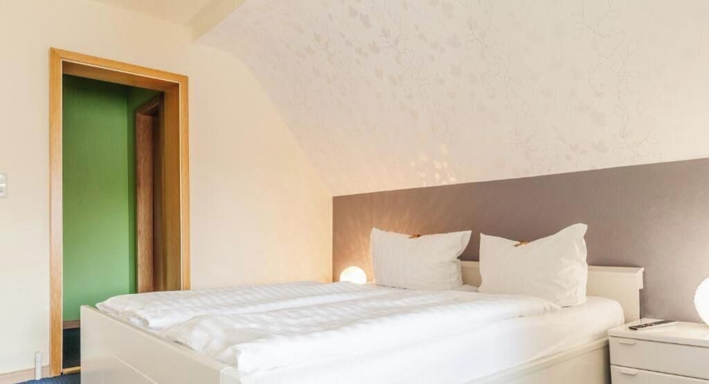 Un dormitorio con una cama, mesitas de noche y una puerta verde.