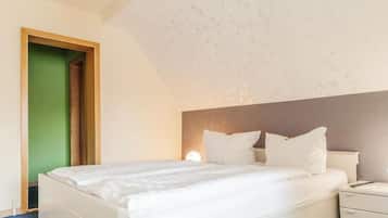 Une chambre à coucher avec un lit, des tables de chevet et une porte verte.