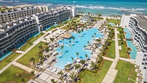 Ein Resort mit einem großen zentralen Pool, mehreren Schwimmpools und Blick auf den Ozean.