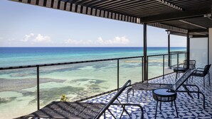 Ein Balkon mit Meerblick, ausgestattet mit Liegestühlen und einem gemusterten Boden.