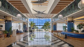 Eine geräumige Lobby mit hoher Decke, großen Fenstern und einer zentralen Sitzecke.