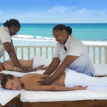 A massage therapy session on a wooden bed with a view of the ocean.