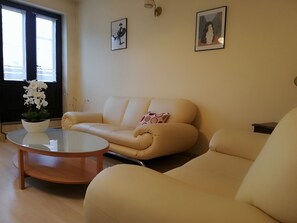 Grand appartement | Woonkamer | Een 50-inch flatscreentelevisie met satellietzenders en televisie