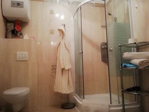 Apartamento grand | Banheiro | Chuveiro, toalhas de banho, sabonete, papel higiênico