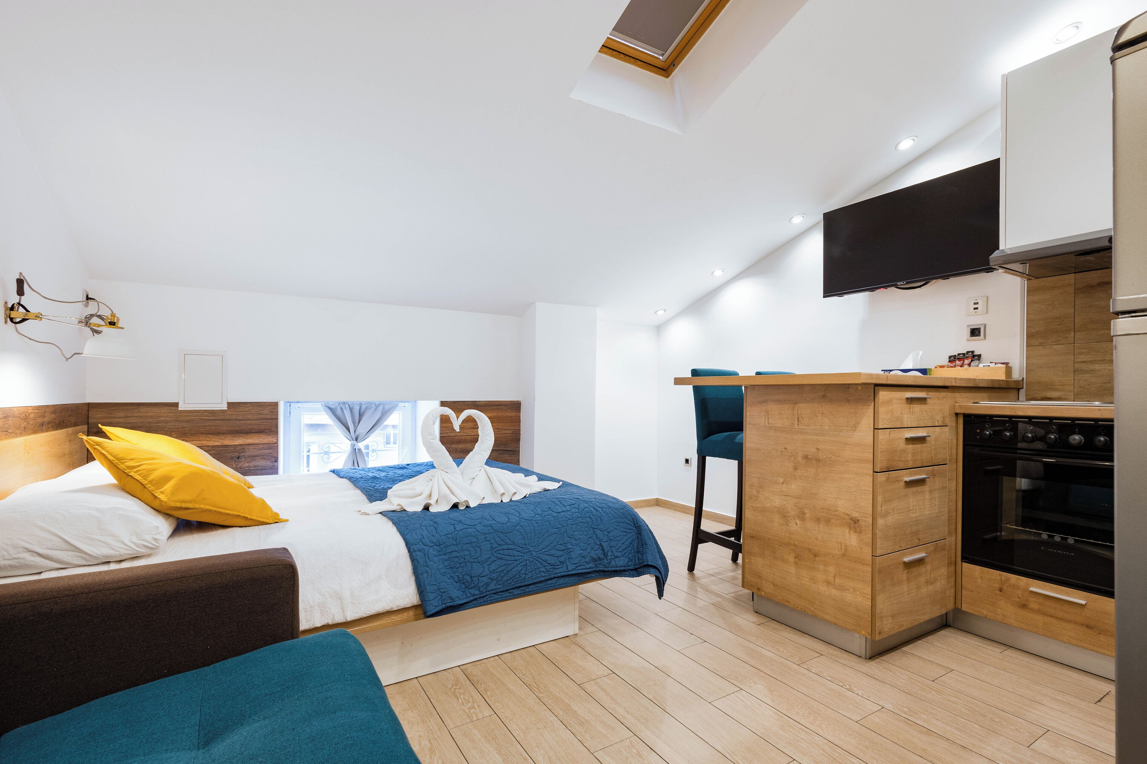 Une chambre moderne avec un lit, un bureau et un coin cuisine.