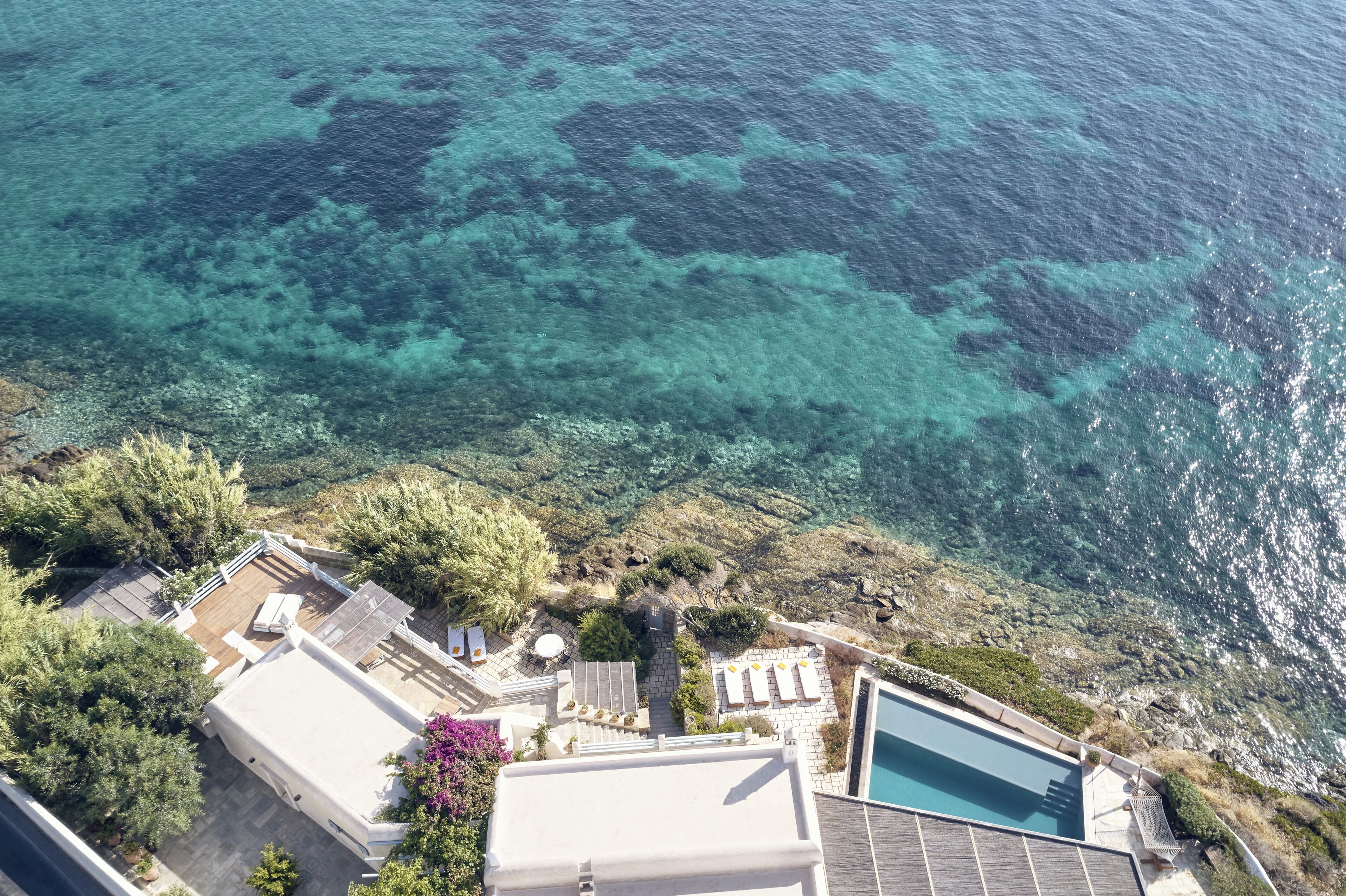 Um imóvel à beira-mar com piscina, área de estar e vista para o mar.