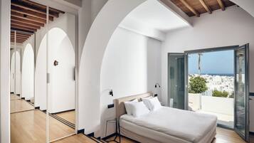 Quarto de hotel moderno com uma cama grande, porta de vidro que dá para uma varanda com vista para a cidade e teto de madeira.