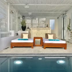 Relax by the serene pool surrounded by lush greenery and comfortable lounge chairs.