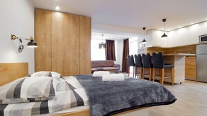 Una habitación de hotel moderna con cama, escritorio y kitchenette.