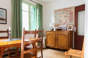 Un coin repas avec une table en bois, des chaises, un buffet et une carte accrochée au mur.