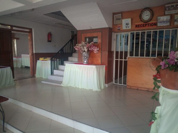 A reception area with a staircase, a reception desk, and a clock on the wall.