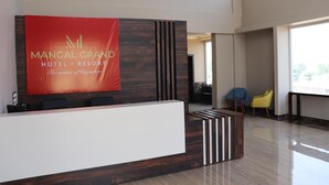 Una mesa de recepción con un gran cartel del Mangal Grand Hotel & Resort.