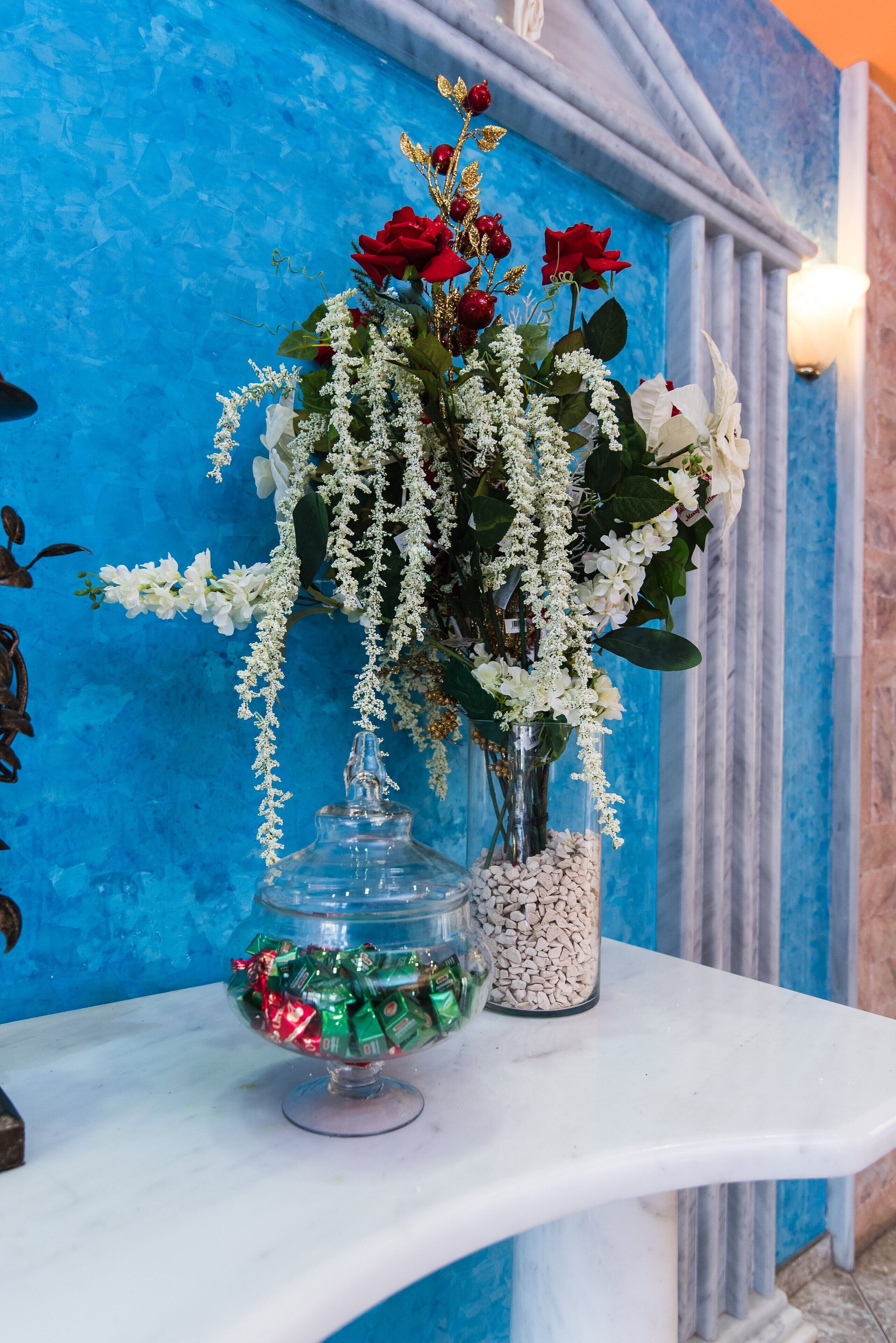 Ein Marmortisch mit einer Blumenvase und einer Schale Süßigkeiten.