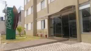A hotel entrance with a sign reading "APOEMA HOTEL," a covered entrance, and potted plants. - Apoema Hotel (Cuiabá)