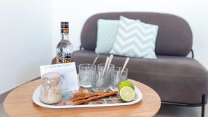 A table with a bottle, glasses, a lime, cinnamon sticks, a jar, and a menu.