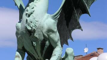 A bronze dragon statue with outstretched wings, positioned on a pedestal.