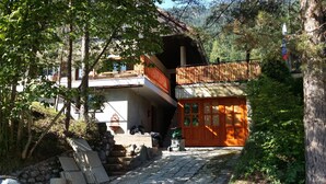 Een rustiek houten huis met een pad van stenen dat naar een houten deur leidt.