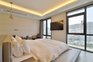 A modern hotel room with a large bed, a desk, a chair, and a TV mounted on the wall. - Busan Seomyeon YUNA Hotel Business (Busan)