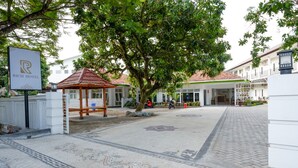 A hotel entrance with a sign, a gazebo, and a tiled pathway. - RedDoorz near Mataram University (Mataram)