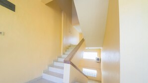 A staircase with a handrail, leading to a landing with a window.
