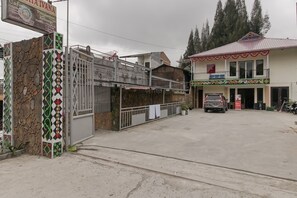A building with a stone facade and a metal gate. - RedDoorz near Tahura Berastagi (Berastagi)