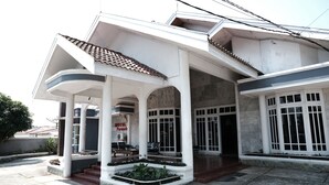 Un hotel con un espacio exterior cubierto, columnas y techo de tejas.