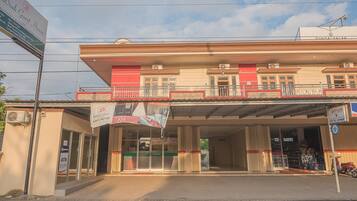 A building with a sign for 'Diah Guest House' and an ATM.
