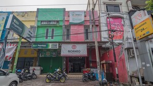 Un escaparate con un letrero que dice 'Borneo Mart' y un letrero que dice 'Pegadaian'.