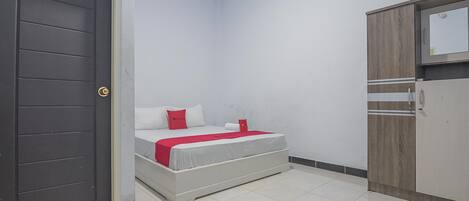 Un dormitorio con cama, armario y puerta.