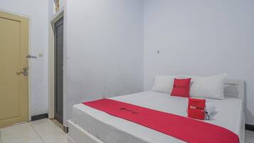 Une chambre d’hôtel avec un lit, une porte et une petite fenêtre.