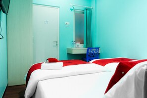 A hotel room with a bed, a bathroom, and a window with curtains. - RedDoorz near Gajah Mada Street Semarang (Semarang)