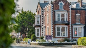 A Victorian-style building with a prominent bay window, brick facade, and a sign indicating "Bunyan Lodge." - Rowntree Lodge (Scarborough)