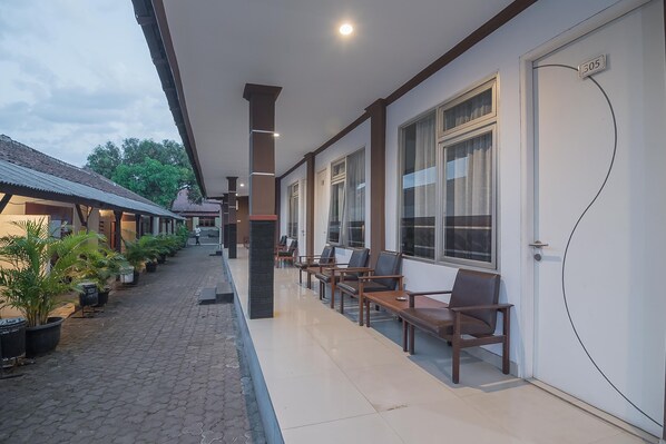 A hotel corridor with seating areas and potted plants. - RedDoorz near Alun Alun Subang (Subang)