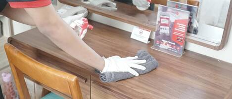 A person cleaning a wooden counter with a cloth.