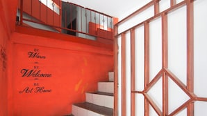 Una escalera con una pared roja y un letrero que dice 'BE Warm BE Welcome BE At Home'.