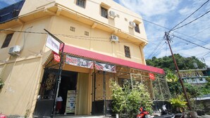 Un edificio de dos pisos con un toldo rojo y un letrero que anuncia servicios de lavandería.